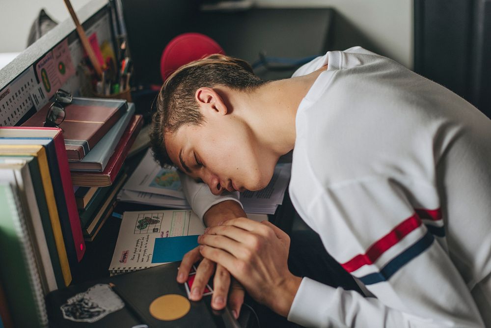 Tired teen asleep on the desk