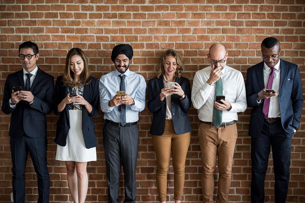 Business people standing and using smartphones
