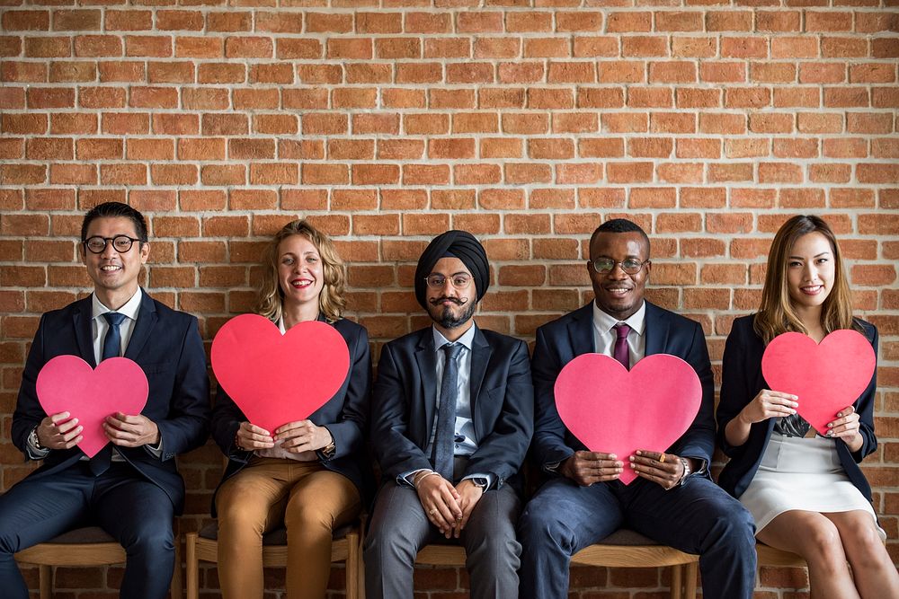 Office people holding red heart symbols