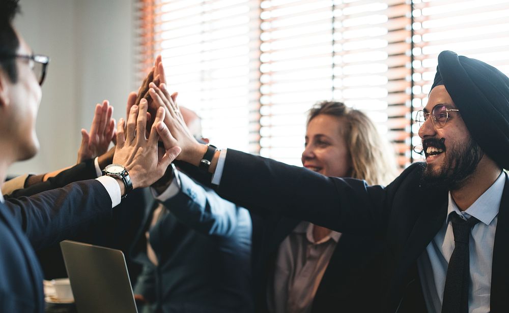 Business people doing a group high five