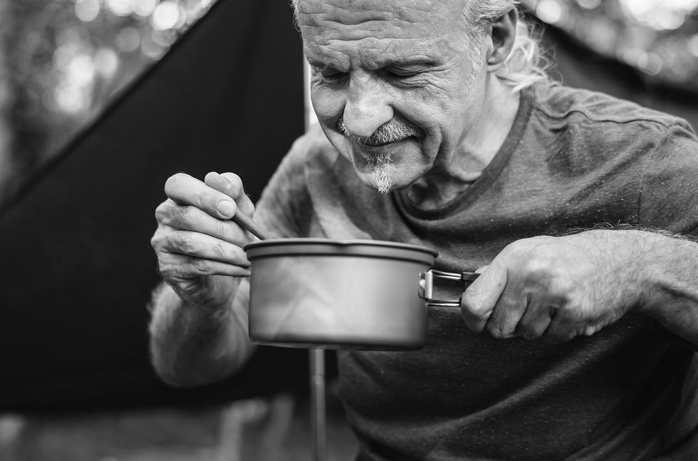 Mature man cooking at a campsite