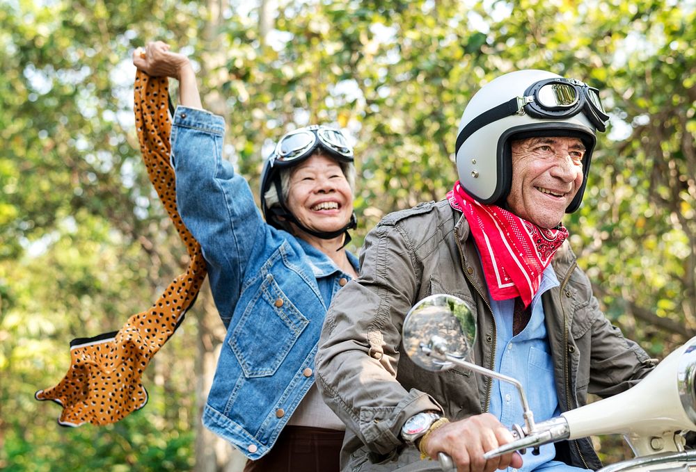 Senior couple riding a classic scooter