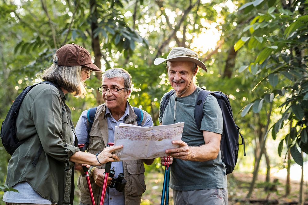 Group of senior trekkers checking a map for direction