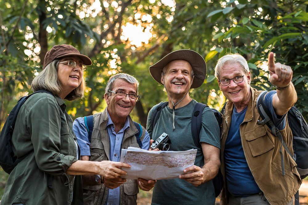 Group of senior trekkers checking a map for direction