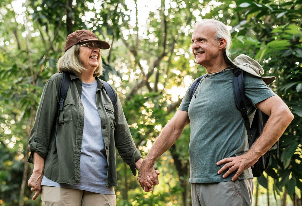 Elderly couple holding hands in the forest