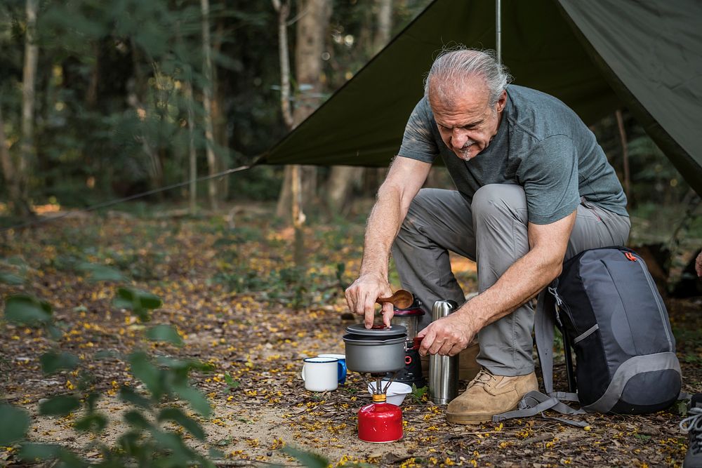 Mature man cooking at a campsite