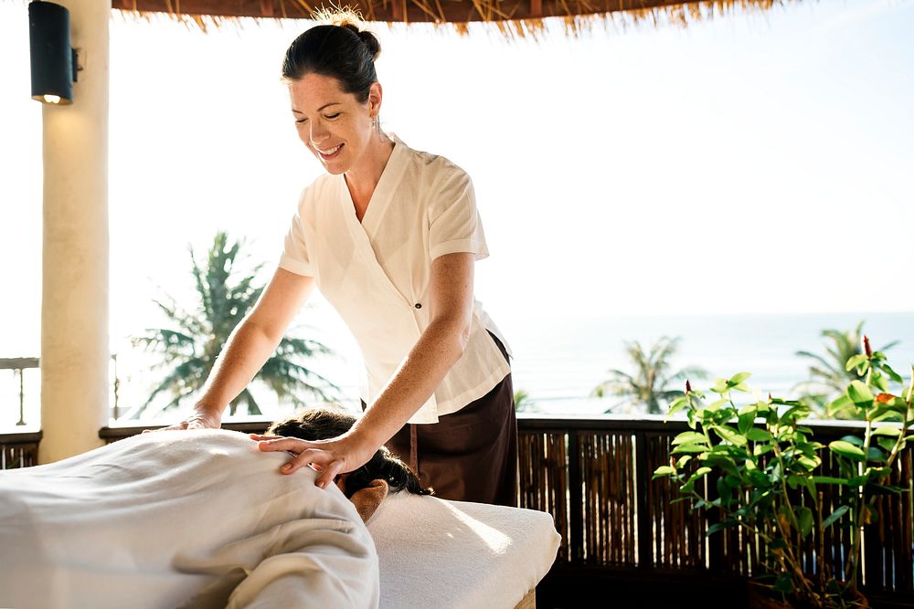 Female massage therapist giving a massage at a spa