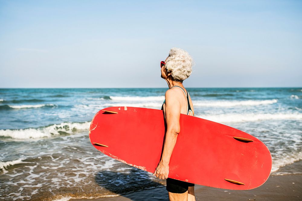 Senior woman holding a surfboard