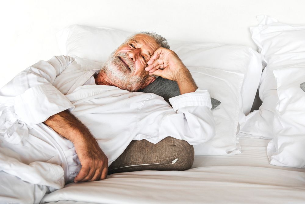 Mature man lying on a bed