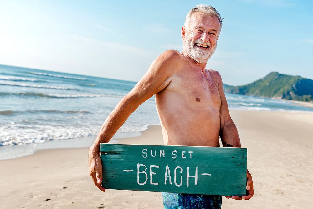 Senior man holding a plank with Sunset Beach