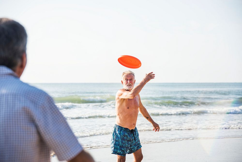 Old man throwing a frisbee to his friend