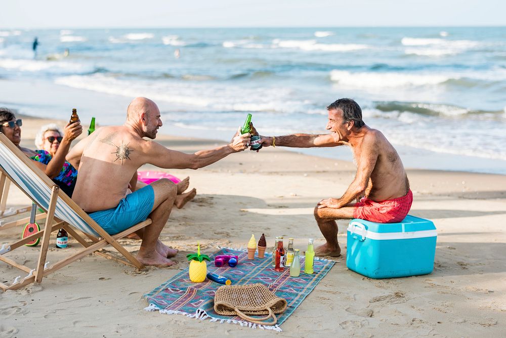 Mature friends having beers at the beach