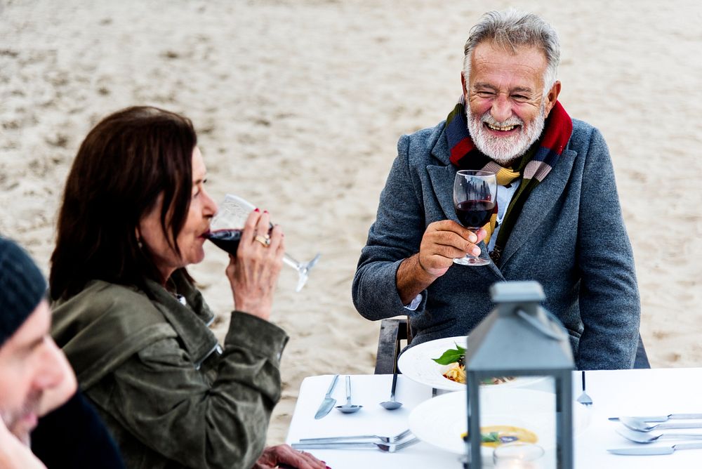 Seniors toasting with red wine at the beach