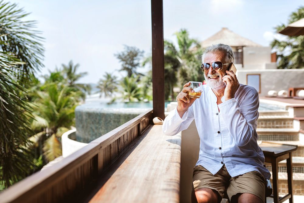 Senior man on the phone having a drink