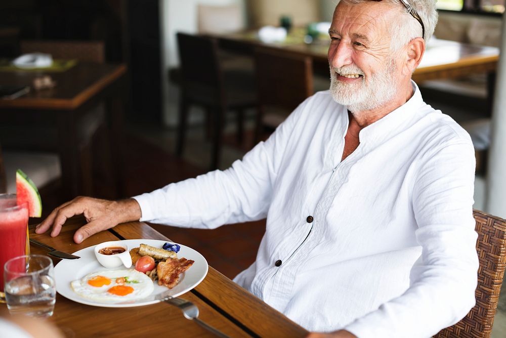 Senior man having breakfast at a hotel