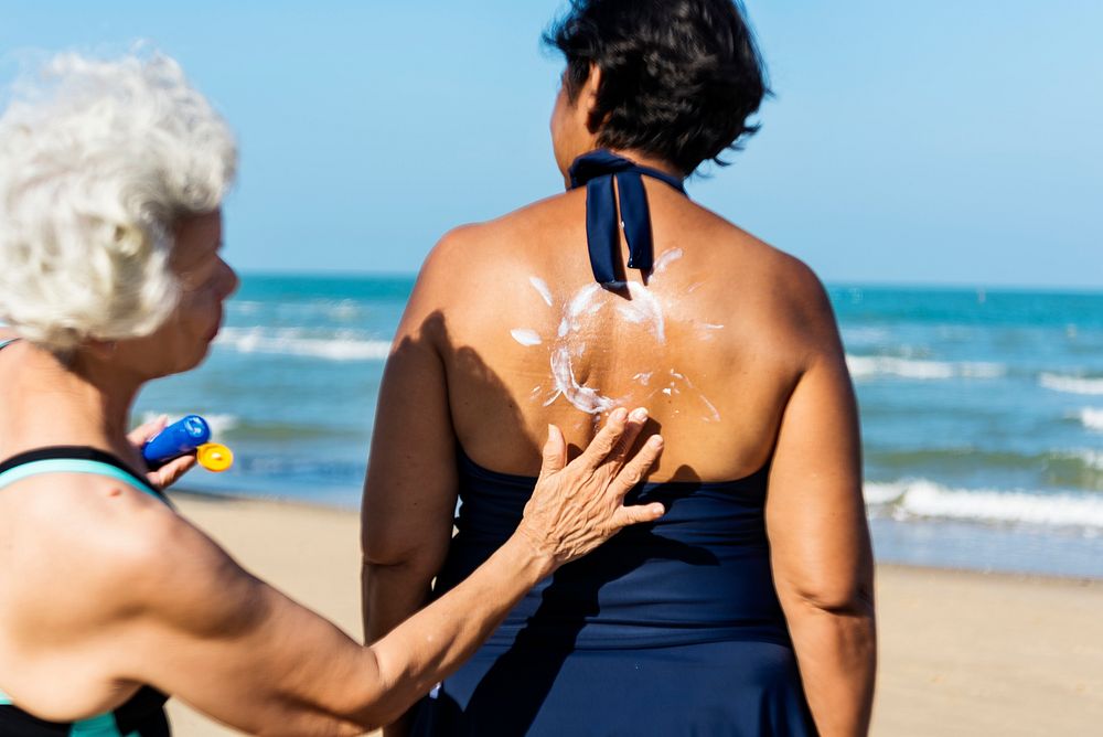 Woman helping to put on sunscreen