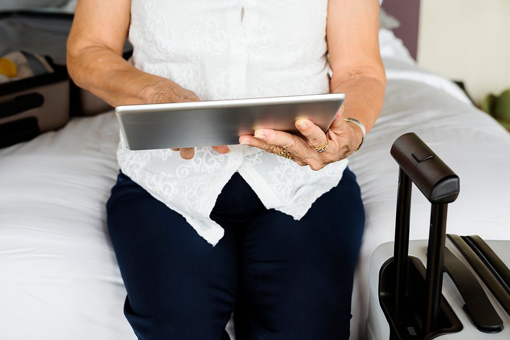Senior woman using tablet on a bed