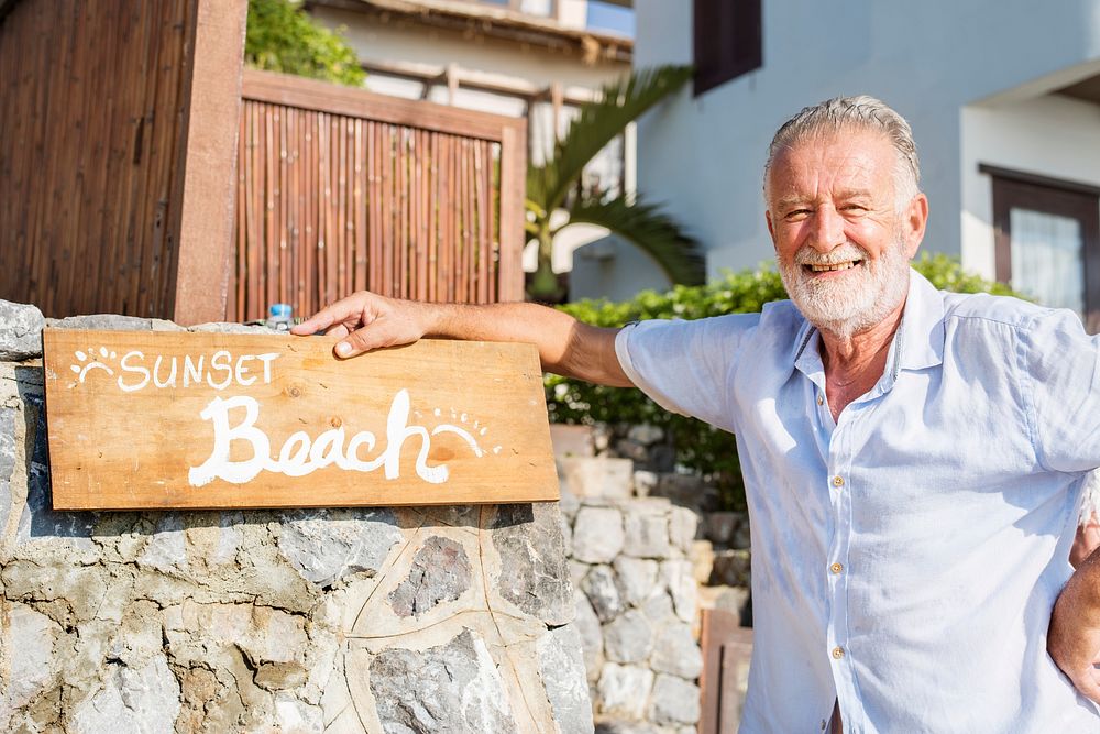 Mature man standing by a resort sign