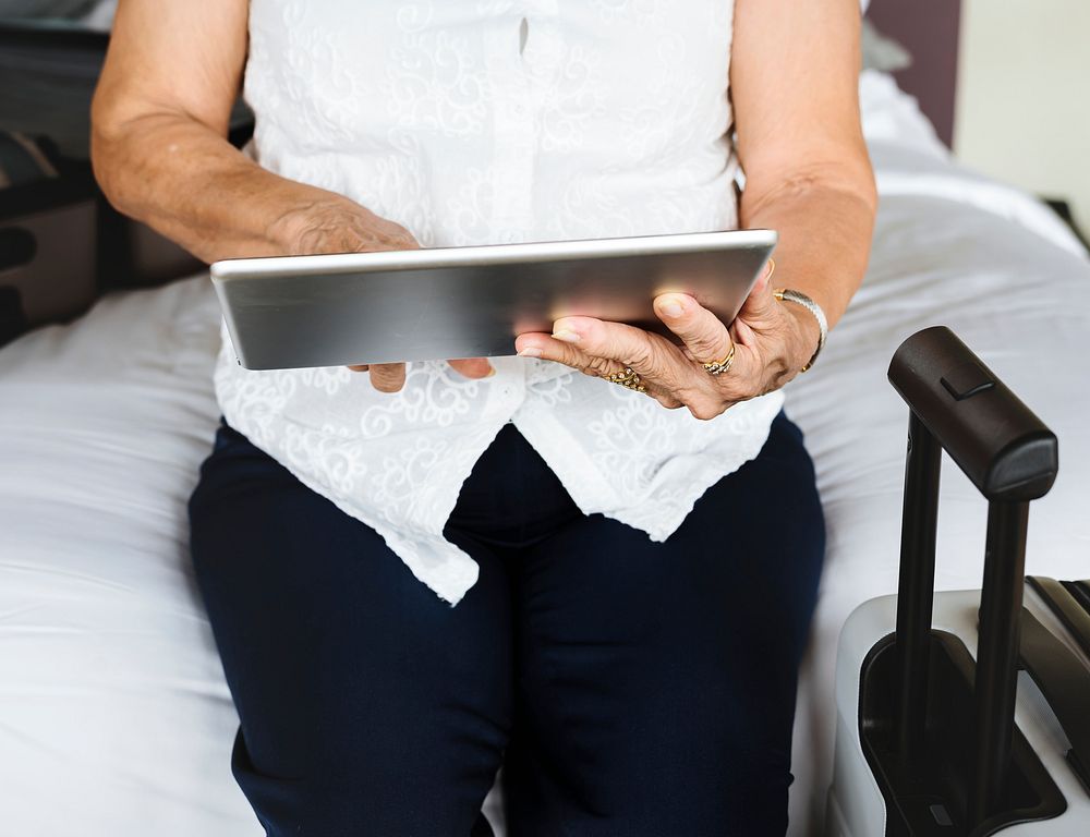 Senior woman using a tablet on the bed