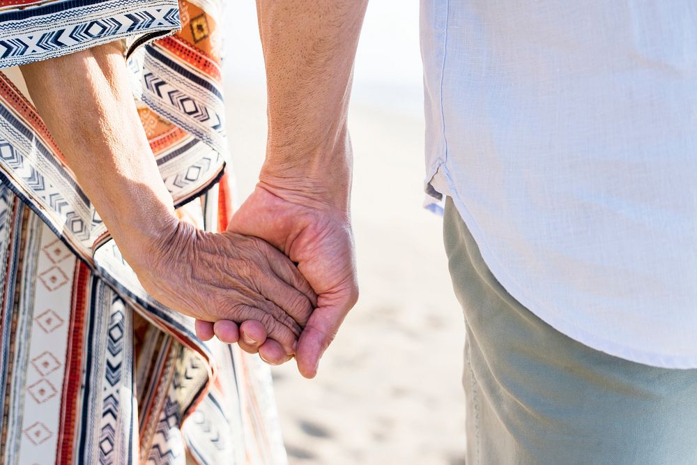 Mature couple holding hands at the beach