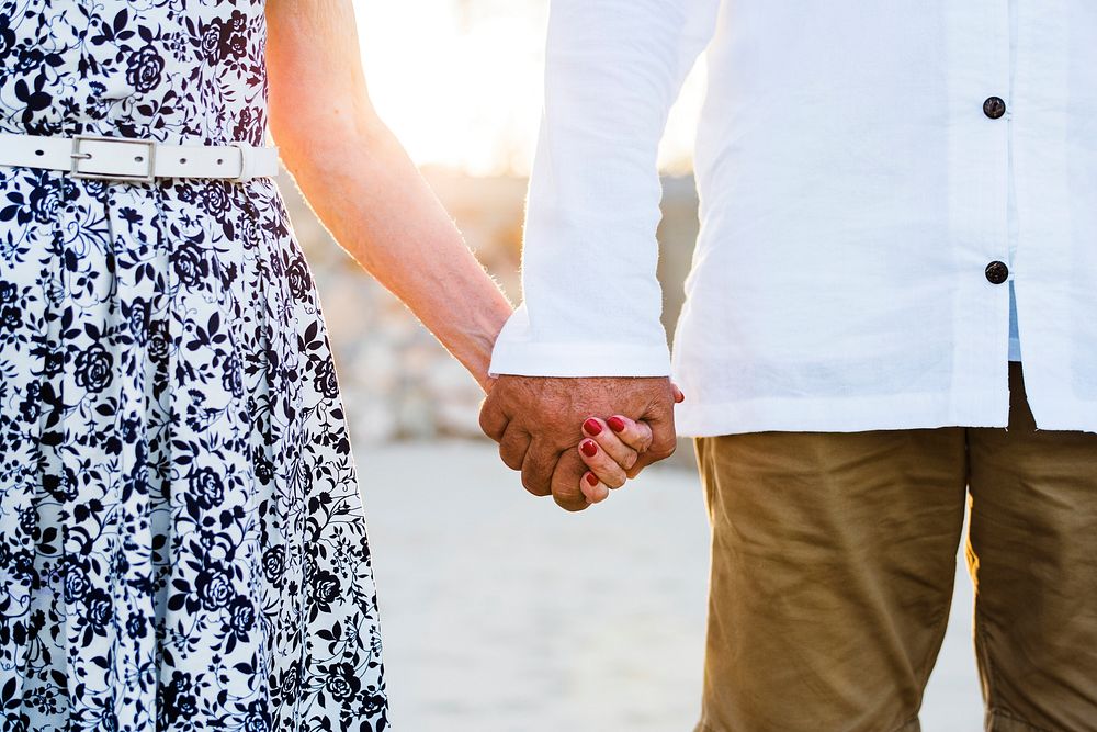 Mature couple holding hands in the sunset