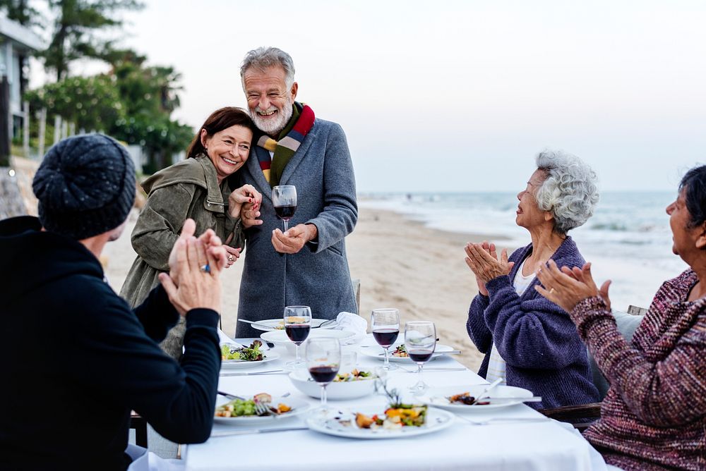 Mature friends having a dinner party at the beach