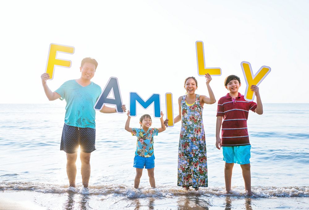 Family holding up letters at the beach