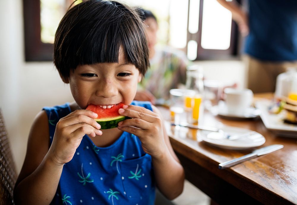 Asian boy snacking on a watermelon