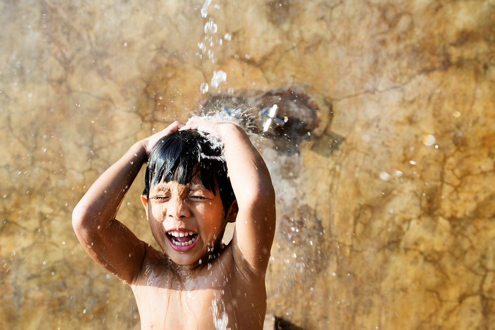 Little boy taking a shower by a swimming pool