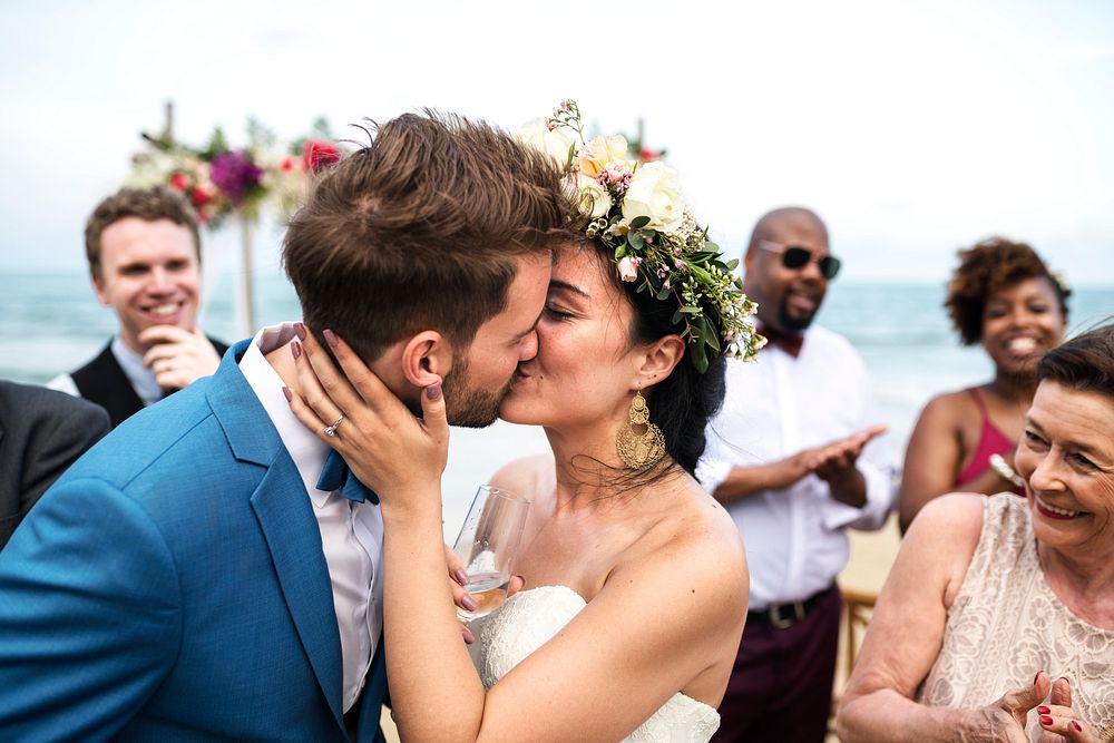 Newly weds kissing at their beach wedding
