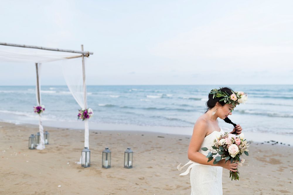 Bride holding a bouquet at the beach