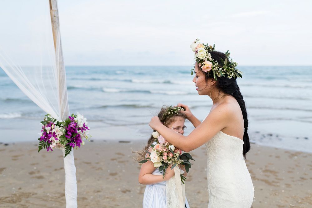 Bride fixing the little girl's floral crown