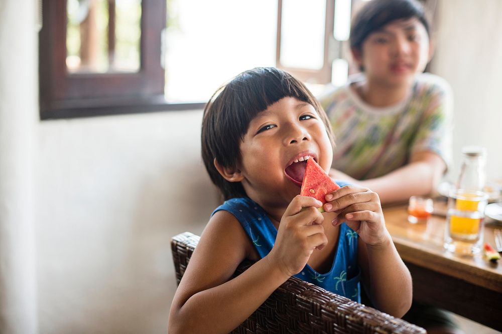 Asian boy snacking on a watermelon