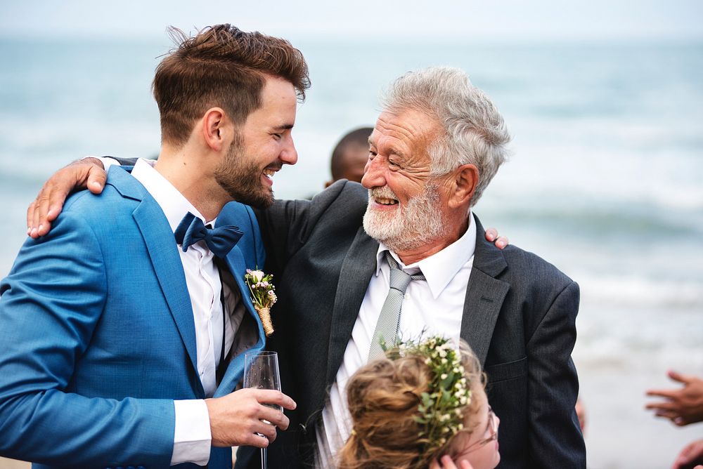 Two men hugging at beach a beach wedding