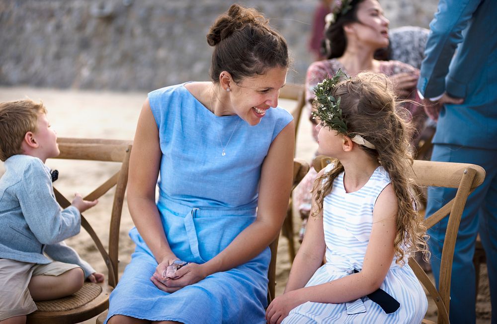 Woman talking to young girl at a beach wedding