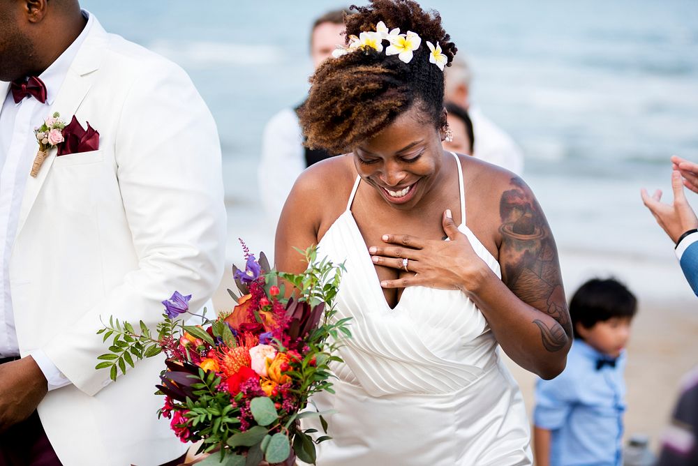Cheerful bride holding a bouquet at her beach wedding