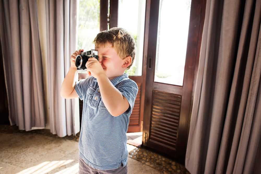 Young boy taking photos with vintage film camera