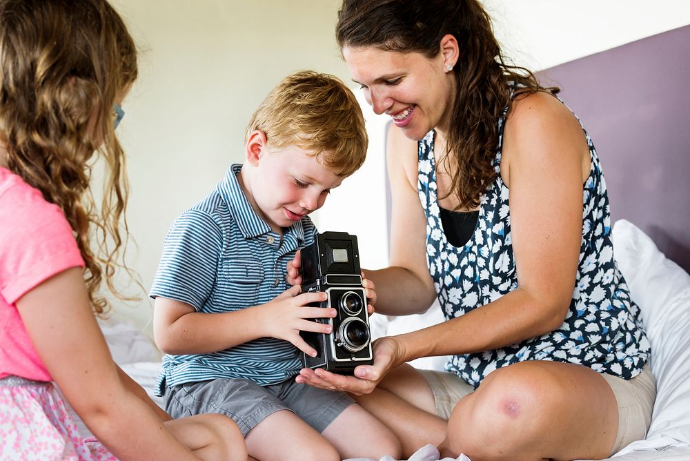 Mother teaching her son to use analog camera