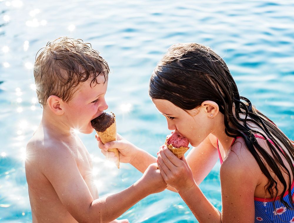 Child sharing an ice cream by the pool