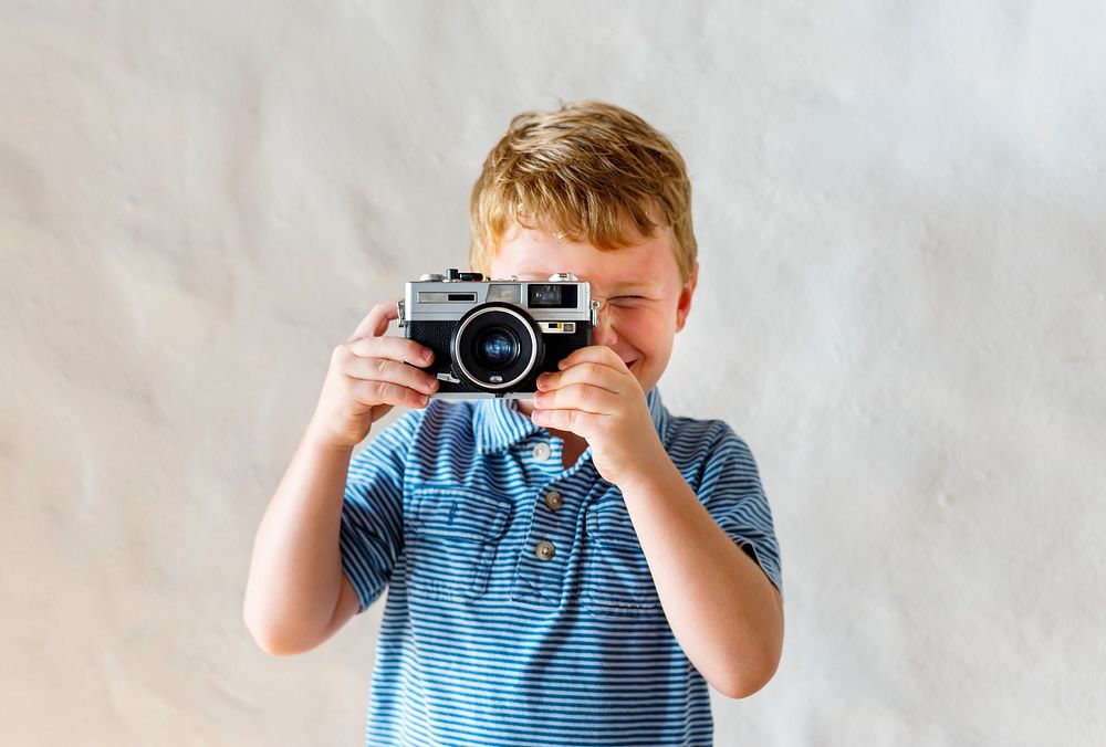 Caucasian boy playing with a camera