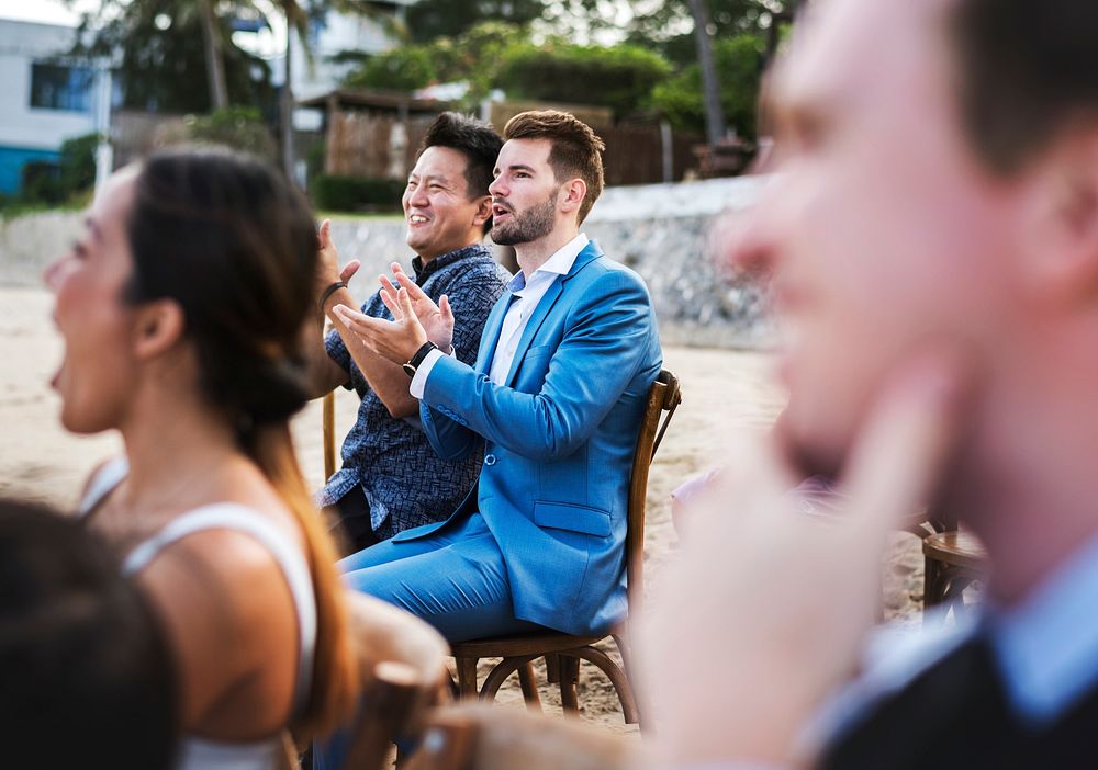 Guests attending a beach wedding ceremony