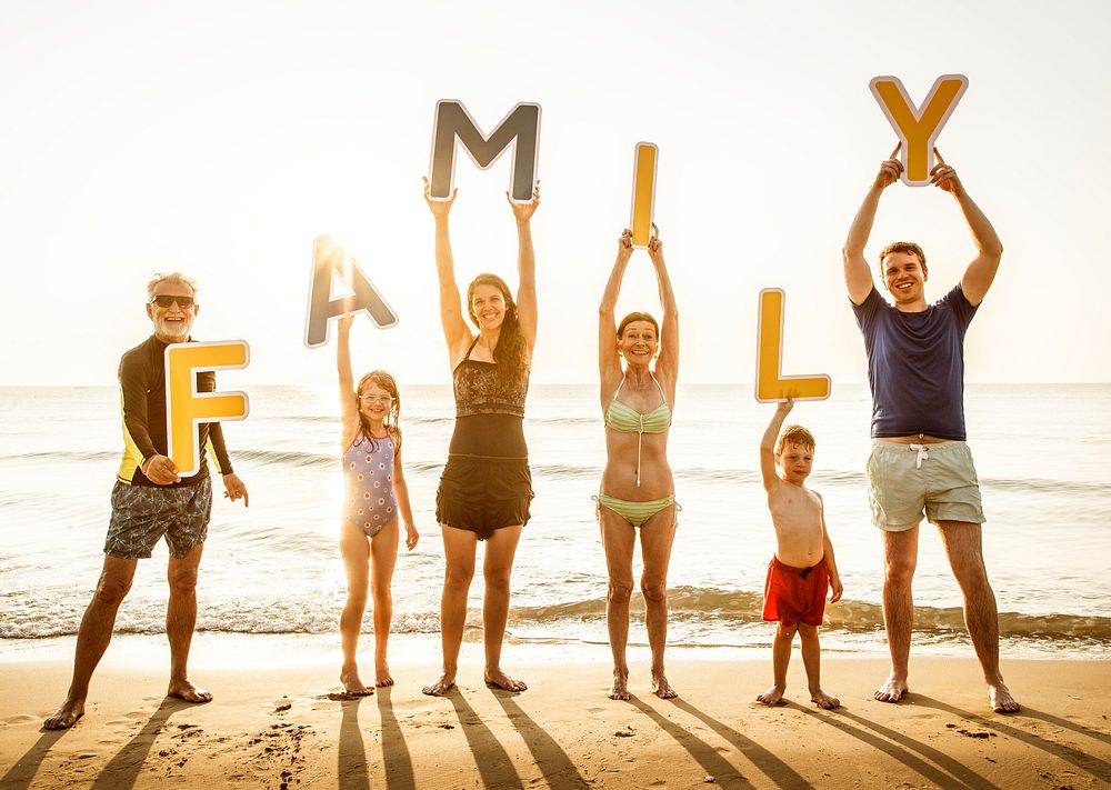 Family holding up letters at the beach