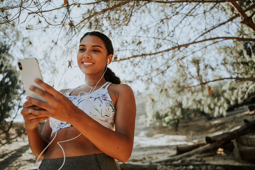 Active woman listening to music through earphones