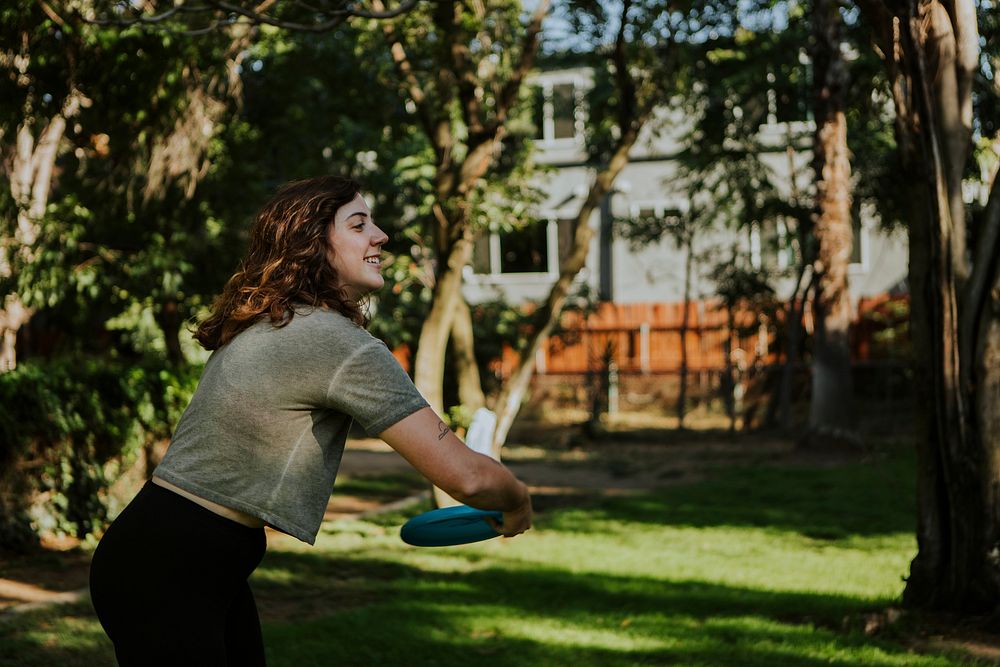 Active woman throwing a frisbee in the park