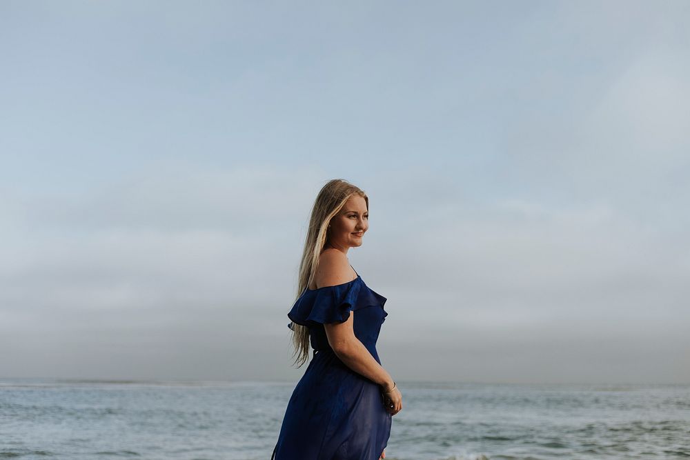 Blonde woman in a blue dress by the water