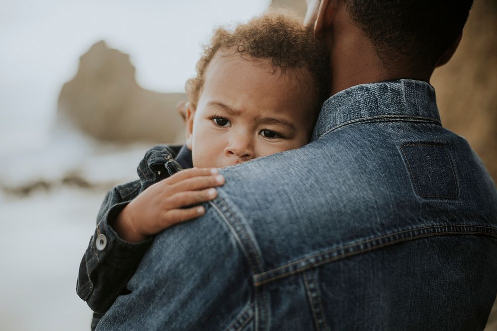 Young boy carried by his dad outdoors