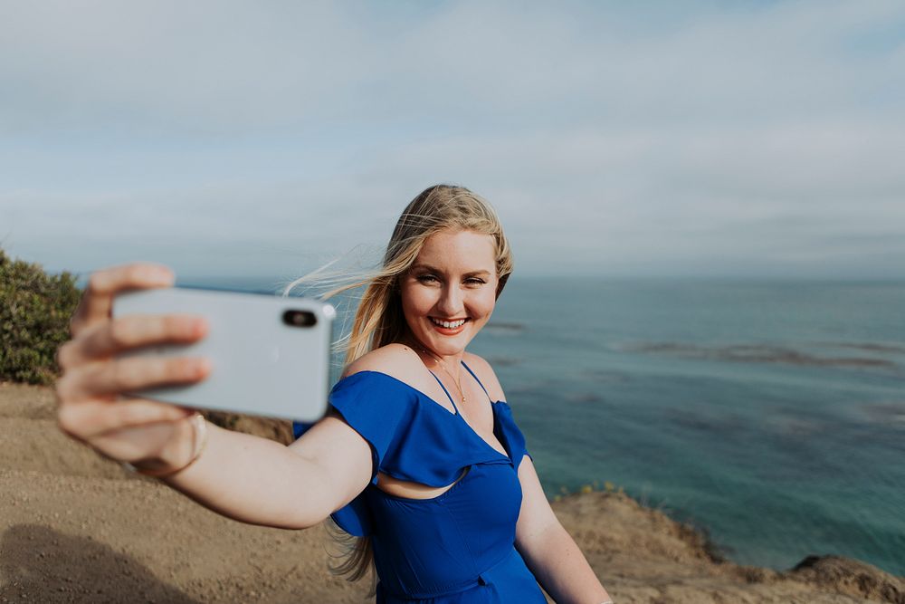 Blonde woman taking photos with her phone