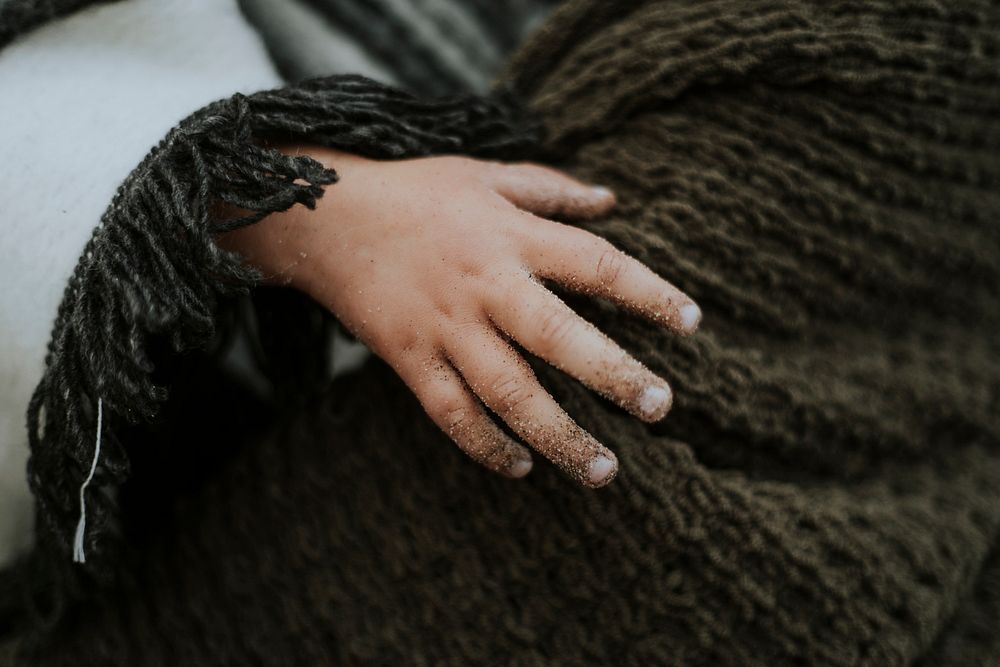 Closeup of a kid's sandy hand