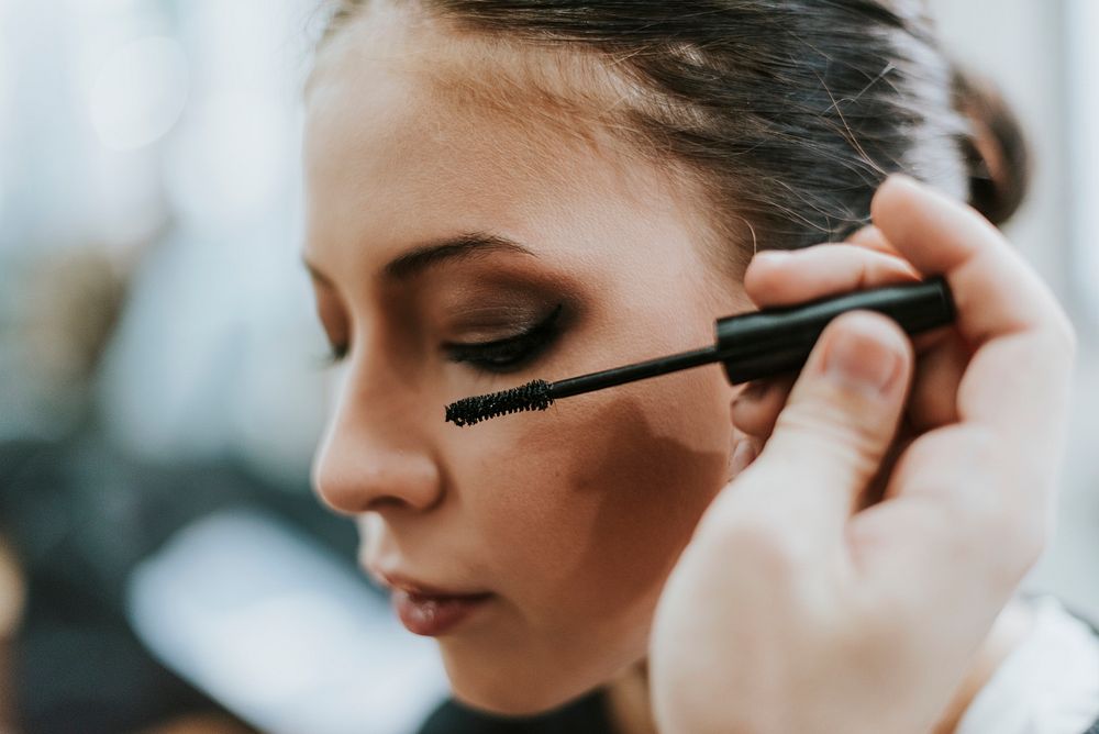 Makeup artist applying mascara onto the model