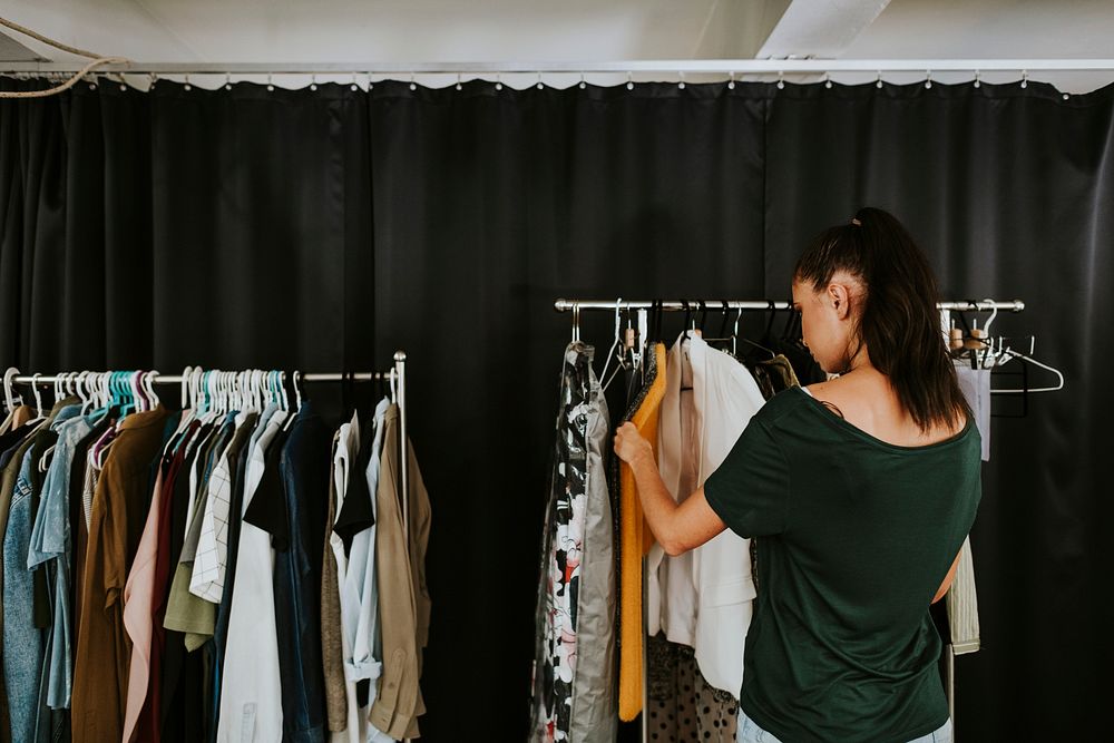 Model picking an outfit from the clothing rack
